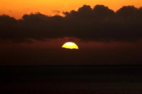 The bright sun between clouds during a nice sunset in Oia, Santorini Stock Photos