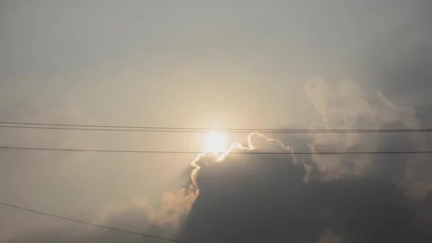 Bright Sun Breaking Through Dark Clouds Over Tree Silhouettes at Sunset Video stock 346898576
