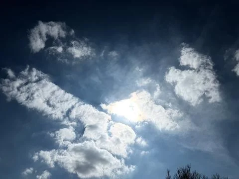 Bright Sun Breaking Through Dramatic Clouds 写真素材