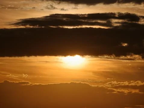 Bright sun breaks through thick cloud layers. Dramatic sunlight streams pas.. 库存照片
