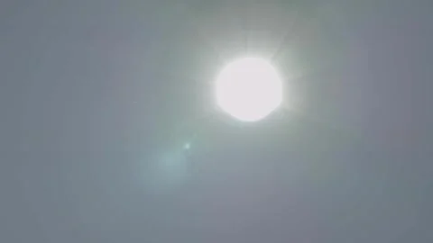 Bright Sun in Clear Daytime Sky with Lens Flare and Hazy Atmosphere Stock Footage 334053256
