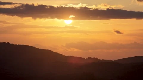 Bright sun disk glowing through orange stratified clouds at sunset, scenic Video stock 327532268