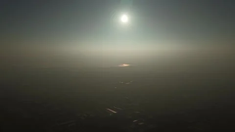 A bright sun disk hanging over a dark, smog-filled industrial horizon during a 스톡 동영상 331116301