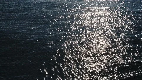 Bright sun glare is reflected in the sea water. Close-up of the reflection of Stock Footage 221413357