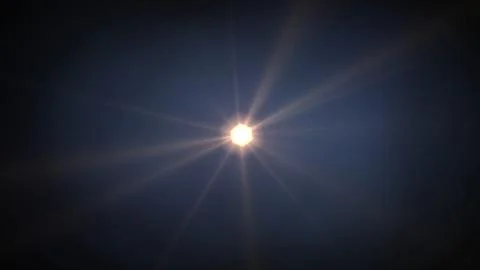 Bright sun glows with radiant beams against deep blue sky Stock Illustration