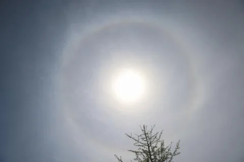 Bright sun halo through thin clouds creating atmospheric sky effect Stock Photos