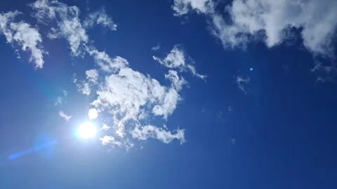 Bright Sun with Lens Flare in Deep Blue Sky with White Clouds Stock Footage 332274738
