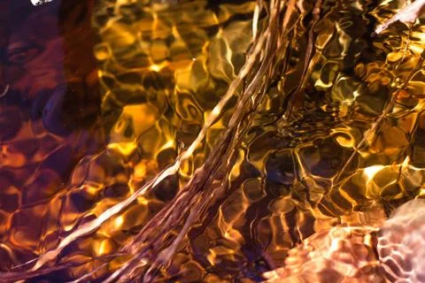 Bright sun rays are reflected in the flowing water and betray its brilliance Stock Photos