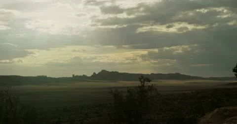 Bright sun with rays &amp; rolling clouds over desert valley timelapse 4K Video stock 11764541