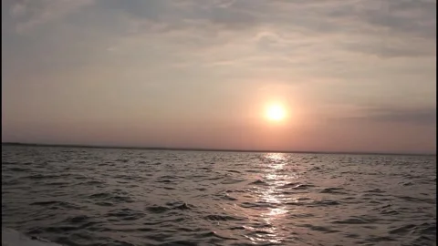 Bright sun reflecting a golden path on the sea at sunset Stock Footage 320090981
