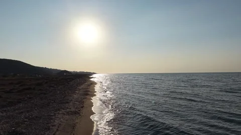 Bright sun reflection on water, and coastal hills. Видео 341527885