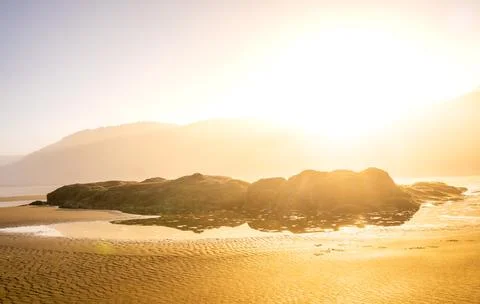 Bright Sun Rises Over Rocks On Hobbit Beach In Oregon Stock Photos