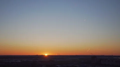Bright sun sets over the horizon in an industrial city Stock Footage 128571828