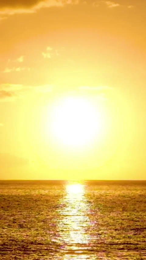Bright sun setting over the tranquil ocean, casting a brilliant golden Stock Footage 344820588