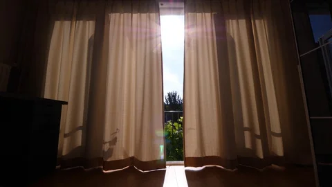 Bright sun shine outside, seen through small opening in curtains Stock Footage 128662616
