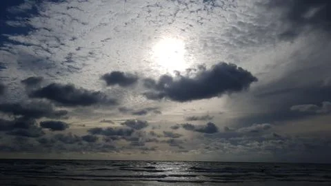 Bright sun shine through the clouds over the sea Stock Photos