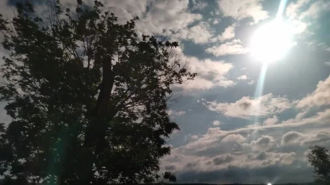 The bright sun shines against a cloudy sky Stock Footage 332330477