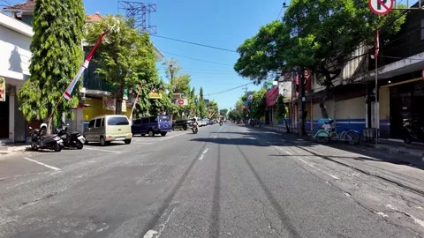 Bright sun shines over a lively street scene Видео 345143232