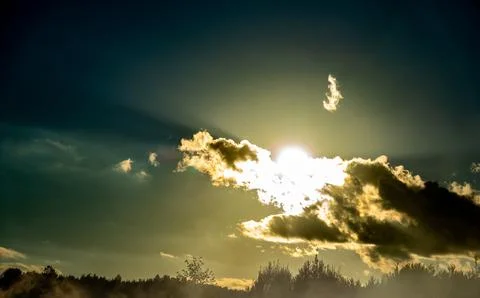 Bright Sun Shining Behind Dark Clouds Over Forest Horizon Stock Photos