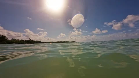 The bright sun is shining brightly through the clouds above the ocean 動画素材 313845671