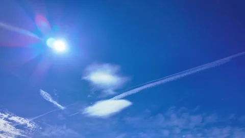 Bright sun shining in a clear blue sky with fluffy clouds timelapse Stock Footage 285178158