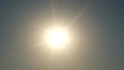 A bright sun shining in a clear blue sky Stock Footage 323377416