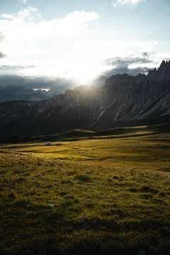 The bright sun is shining down through the fluffy clouds above the mountains Foto stock