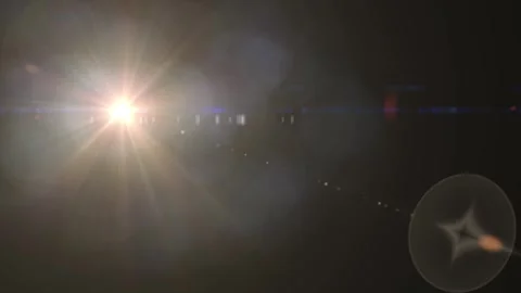 Bright sun shining over dark landscape with lens flare and starburst effects Video stock 338301474