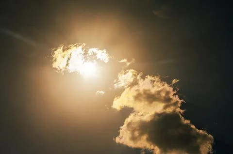 Bright sun shining through dramatic clouds, creating a warm, ethereal glow .. Stock-Fotos