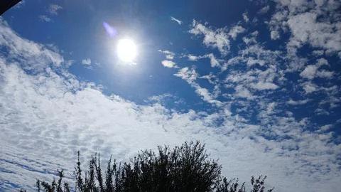 Bright Sun Shining Through Textured Clouds 스톡 사진