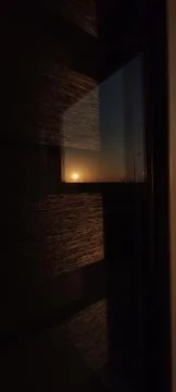The bright sun is shining through a window in a very dark room Stock Photos