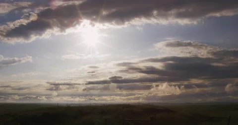 Bright sun shining from under a layer of dark gray clouds Video stock 59328246