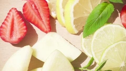 In bright sun a slice of juicy fruit and drink in a glass slow motion Stock Footage 90418890