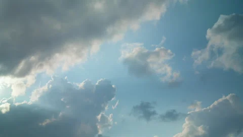 Bright sunbeams break through cumulus clouds in blue sky with storm clouds. Stock Footage 340039756