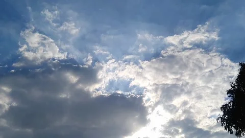 Bright Sunbeams Breaking Through Clouds in Blue Sky Stock Footage 339168069