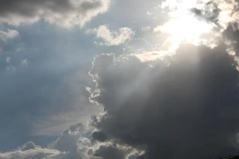 Bright sunbeams breaking through dramatic dark storm clouds Stock Photos
