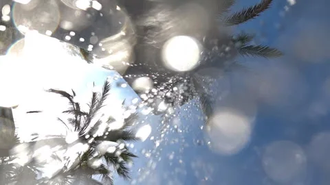 Bright sunlight creating bokeh and lens flare effect through splashing water Stock Footage 339813743