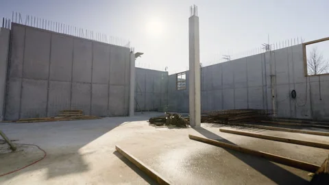 Bright sunlight creating sharp shadows on concrete walls, exposed metal rebar Stock Footage 306393488