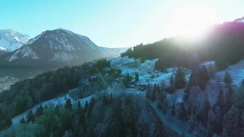 Bright Sunlight Over Snow-Dusted Alpine Forest and Winding Road 動画素材 334279335