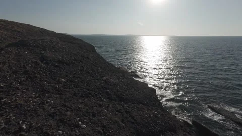 Bright sunlight reflecting on water surface along rocky irish coastline Stock Footage 340458839