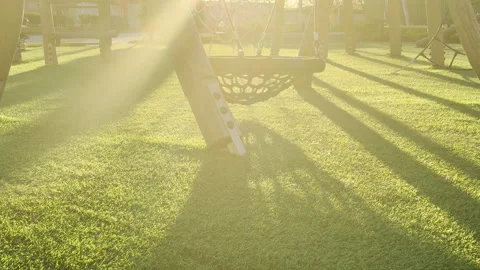 Bright Sunlight Shines Over a Quiet Playground and Empty Nest Swing in a Park Stock Footage 335144603