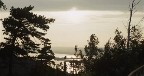 Bright sunlight shining over lake and forest at sunset Stock Footage 304299804