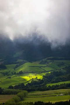 Bright sunlight shining through hole of clouds to dark scene of mountain rang Stock Photos