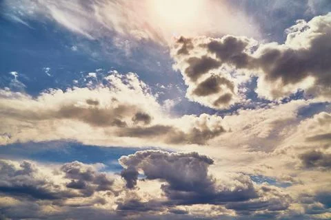 Bright sunlight through clouds in blue sky Stock Photos