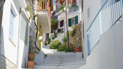 A bright, sunlit view of a narrow stepped alleyway in Skopelos town, Greece Stock Footage 346674184