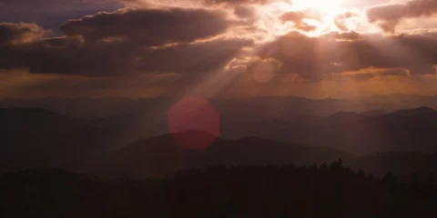 Bright sunrays falling on the mountain ranges covered with forest Stock Footage 103400015