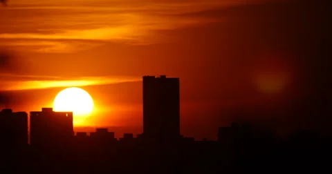 Bright Sunrise Through Building Silhouettes Timelapse 4K Stock Footage