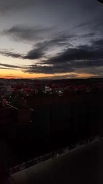 Bright sunset casts colors over the bustling city below Stock Photos