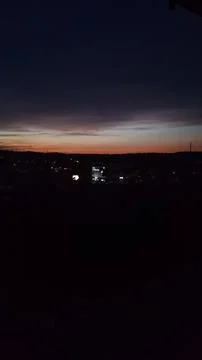 Bright sunset casts colors over the bustling city below Stock Photos