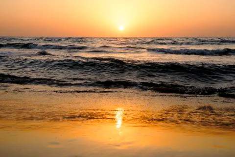 A bright sunset in a cloudless sky on the Mediterranean Sea with waves in Isr Stock Photos